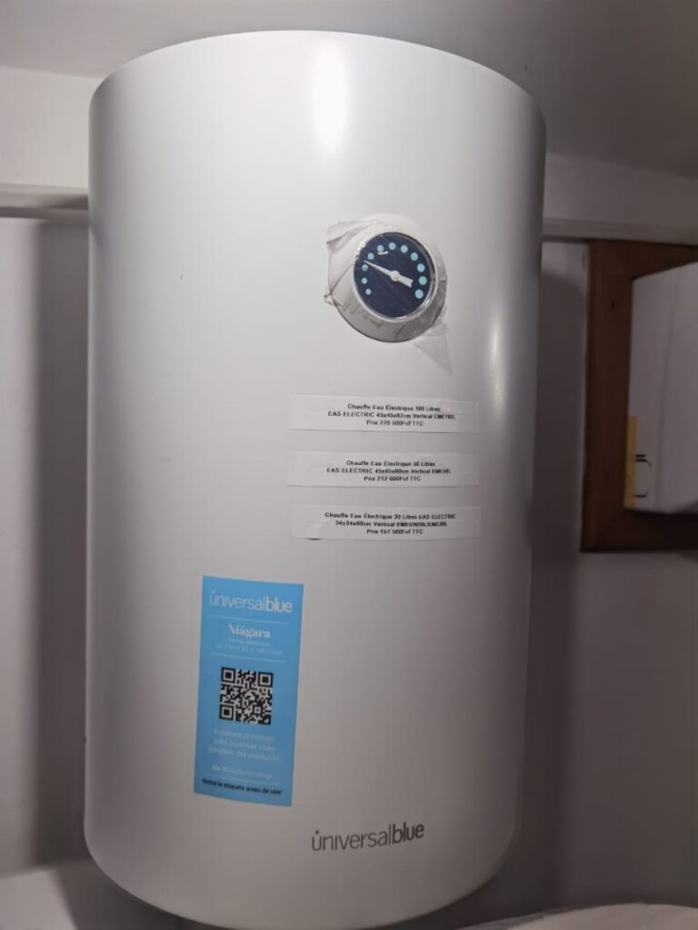 Un chauffe-eau électrique blanc de marque Universal Blue avec des indications de prix et des instructions affichées, installé dans une maison à Garches.